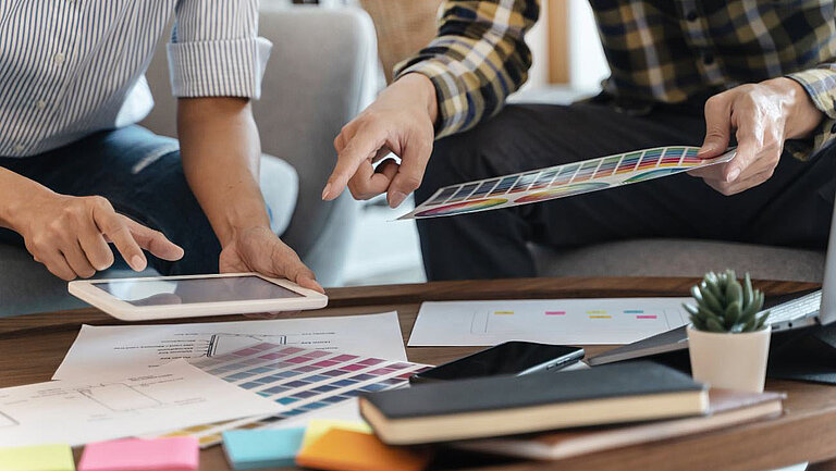 Two people work on the structure and colour scheme of a website